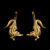 A set of two mirrored gold alligator hair slides against a black background.