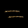 A pair of two gold spiked bamboo hair slides against a black background.