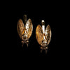 Gold Cicada hair slides against a black background. 