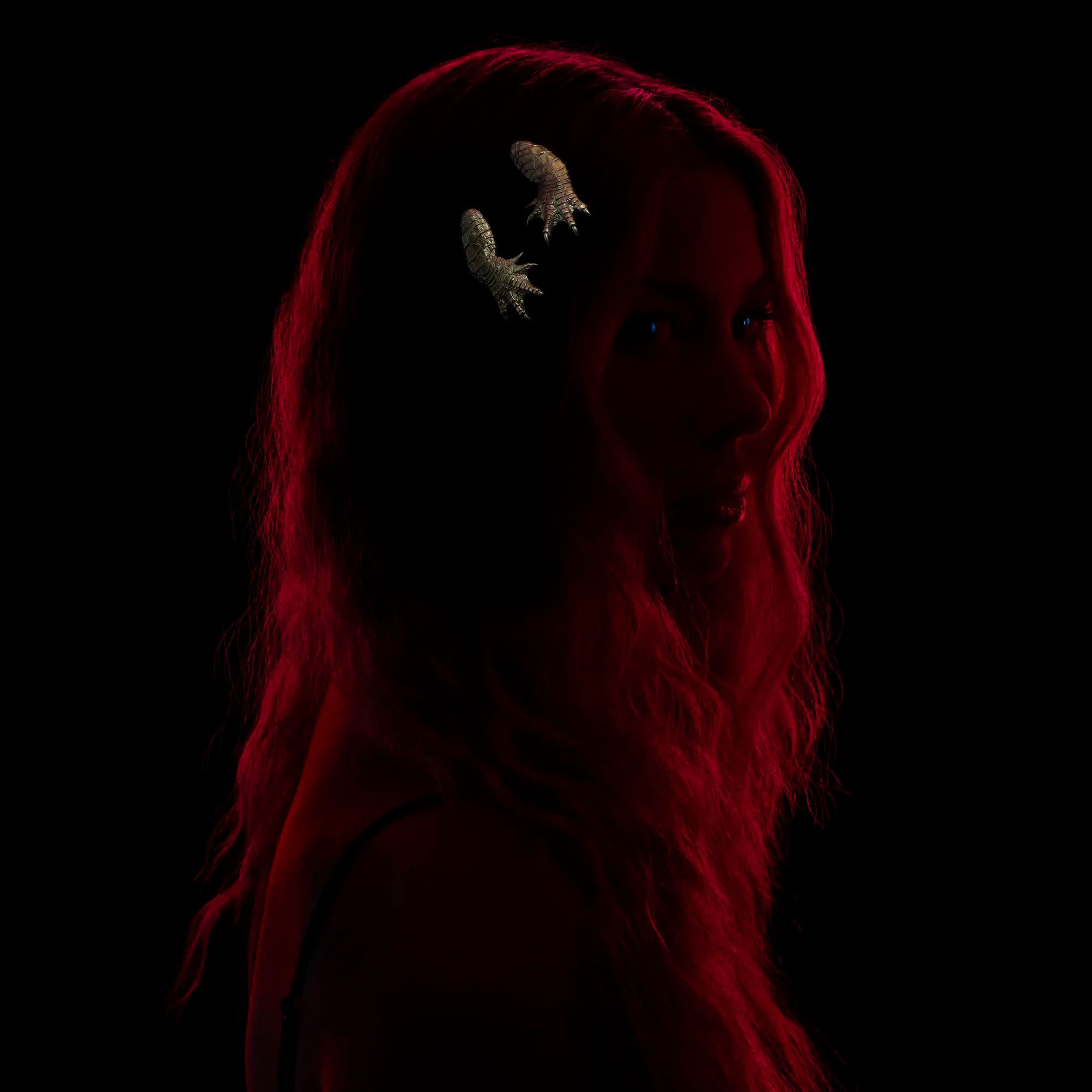 Model wearing two gold alligator claw hair slides against a black background.
