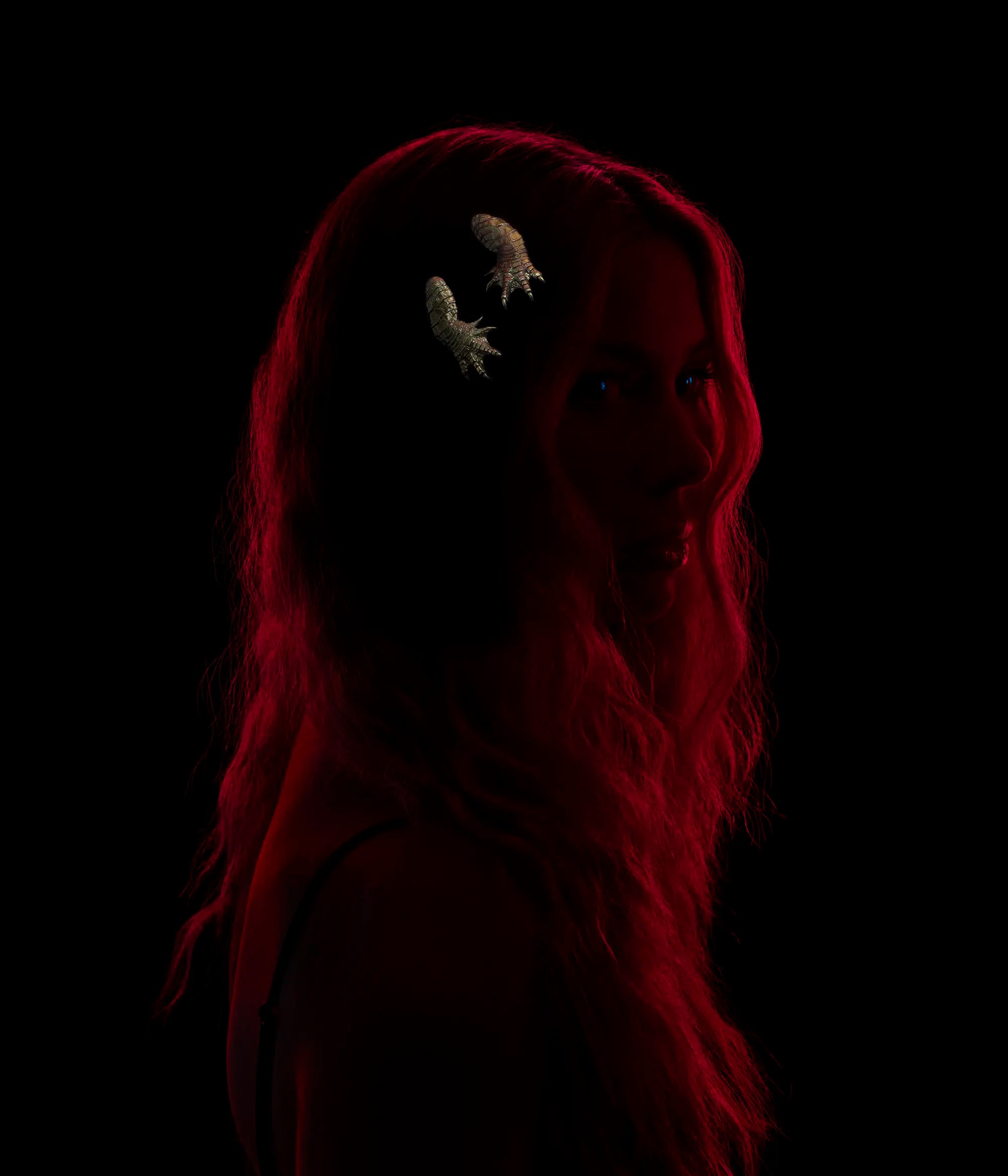 Model wearing two gold alligator claw hair slides against a black background.