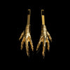 A set of two mirrored gold chicken feet hair slides against a black background. 