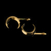 Set of two gold crescent moon hair slides against a black background.