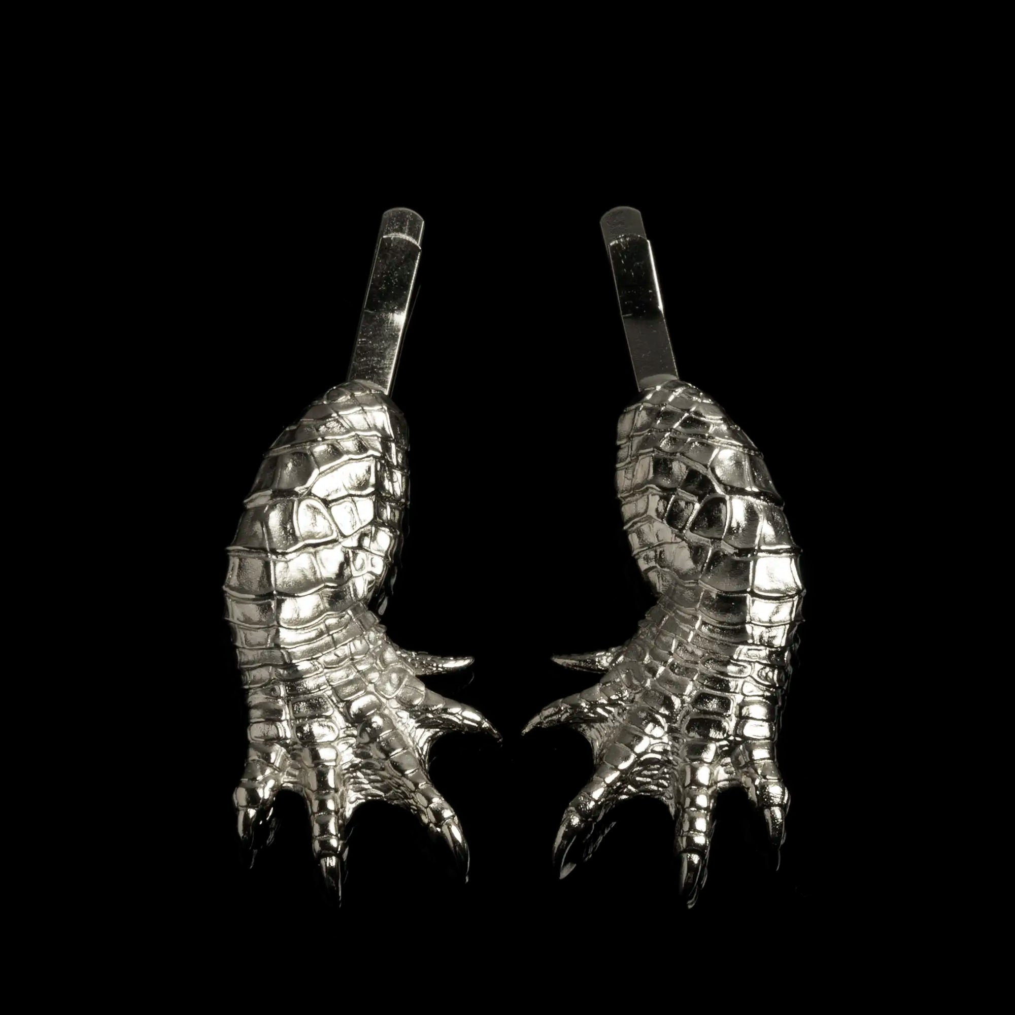 A set of two mirrored rhodium Alligator Claw Hair Slides against a black background.