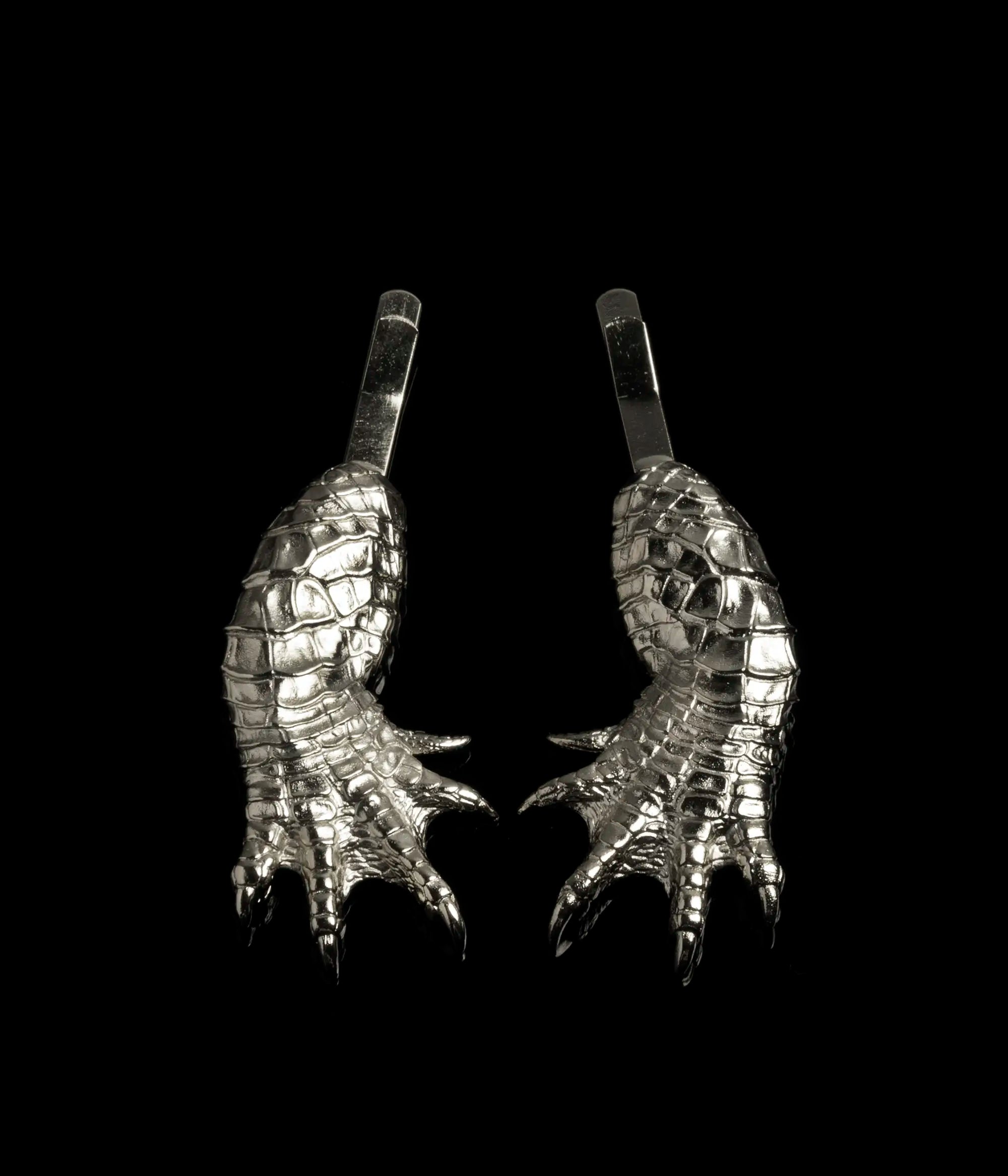 A set of two mirrored rhodium Alligator Claw Hair Slides against a black background.